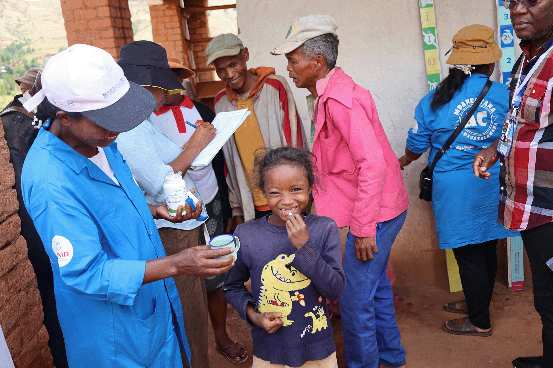 A little girl receiving a drug treatment during a one health approach to Integrate interventions to control of schistosomiasis and Taenia solium