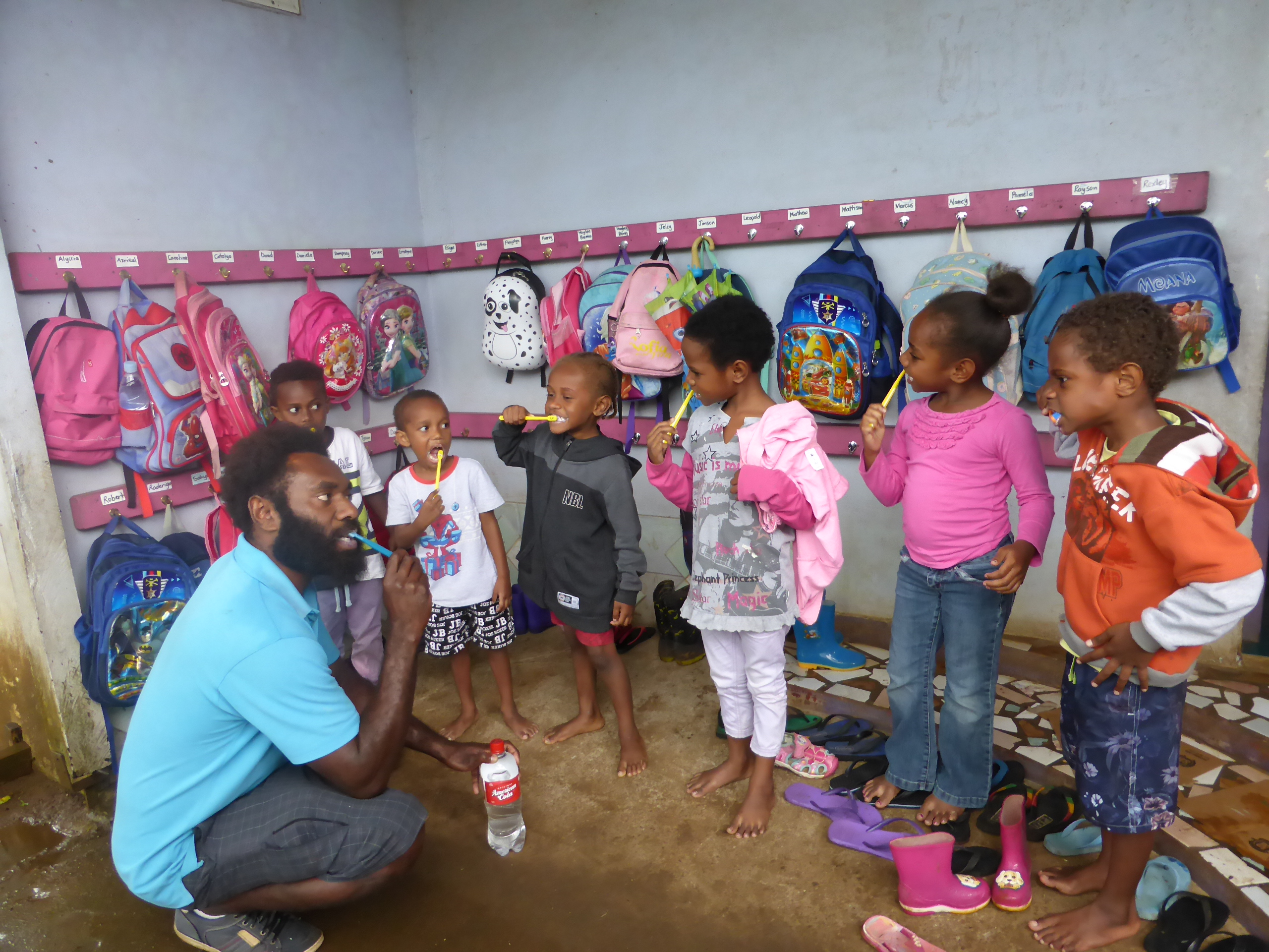 A dental assistant is teaching students how to brush teeth in Port Vila, Vanuatu.